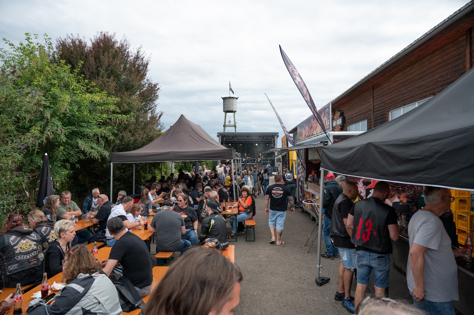 Biergarten mit langen Tischen voller Gäste