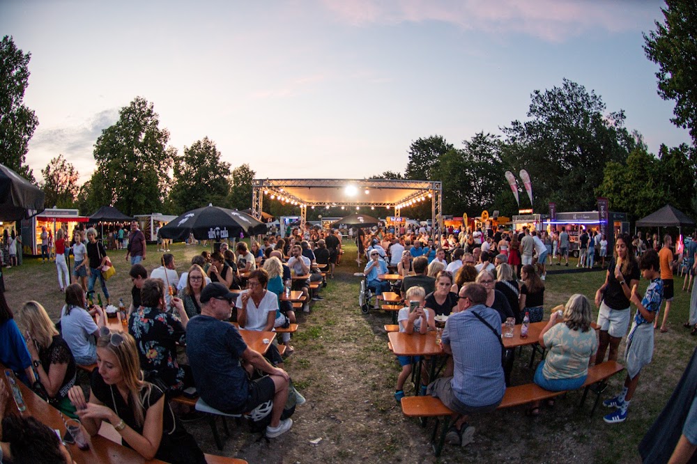 Großes Firmen-Sommerfest mit Team, Bühne und Foodtrucks in der Abenddämmerung